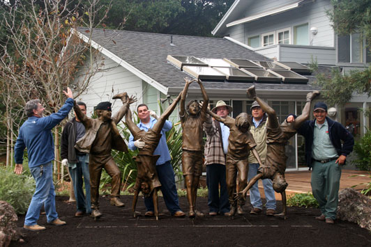 Picture of men at work posing with bronze statue